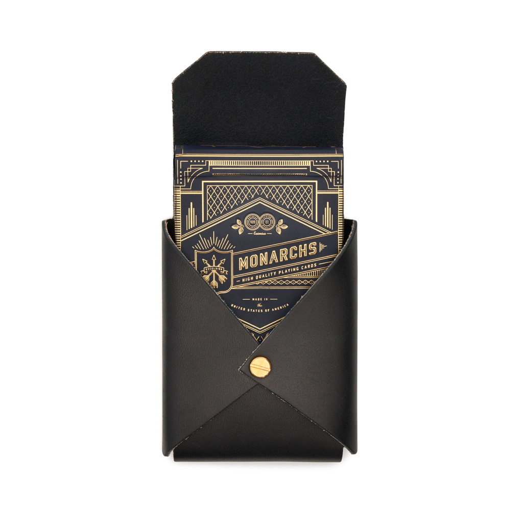 Black leather playing card case with Monarchs playing cards visible and brass snap