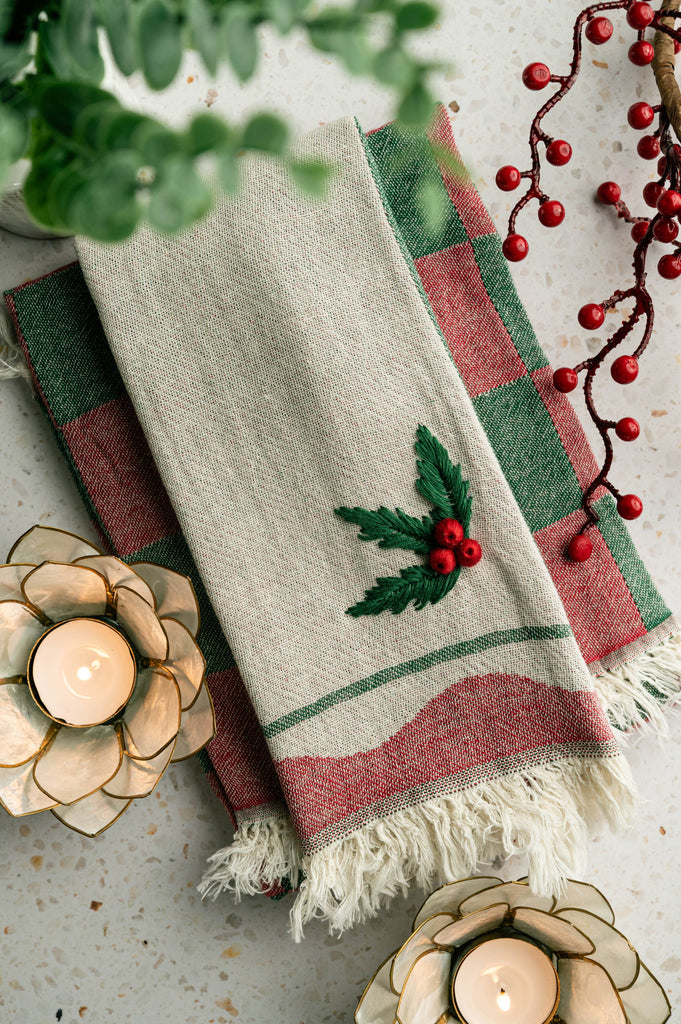 Cream tea towel with holly berry applique and green/red plaid stripes, fringed hem