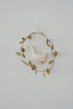 Paper mache duck ornament in circular leaf garland, hanging from white cord
