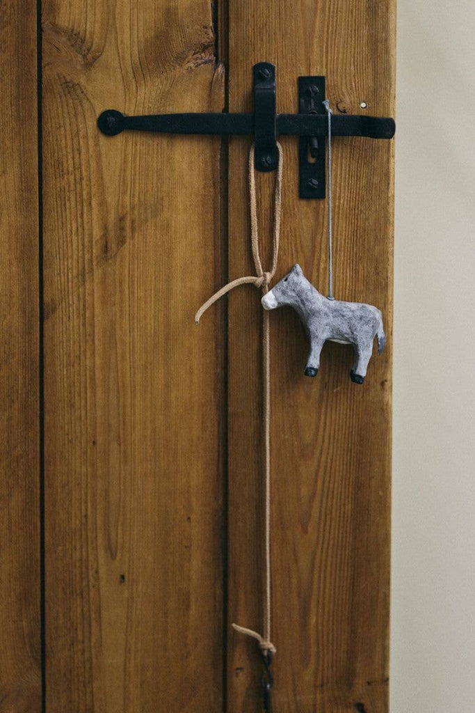 Paper mache polar bear ornament, light gray, hanging from curved cord