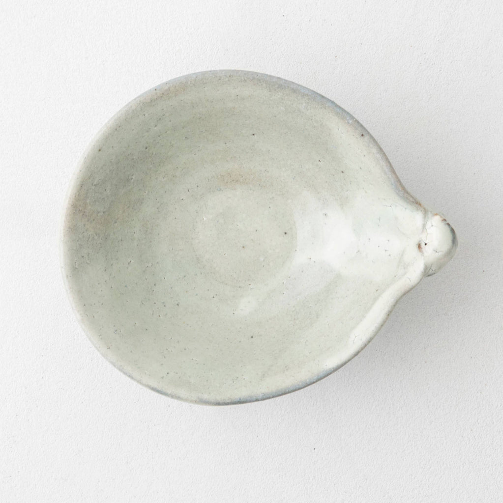 Handmade Japanese ceramic bowl interior, smooth light gray with rounded rim and spout