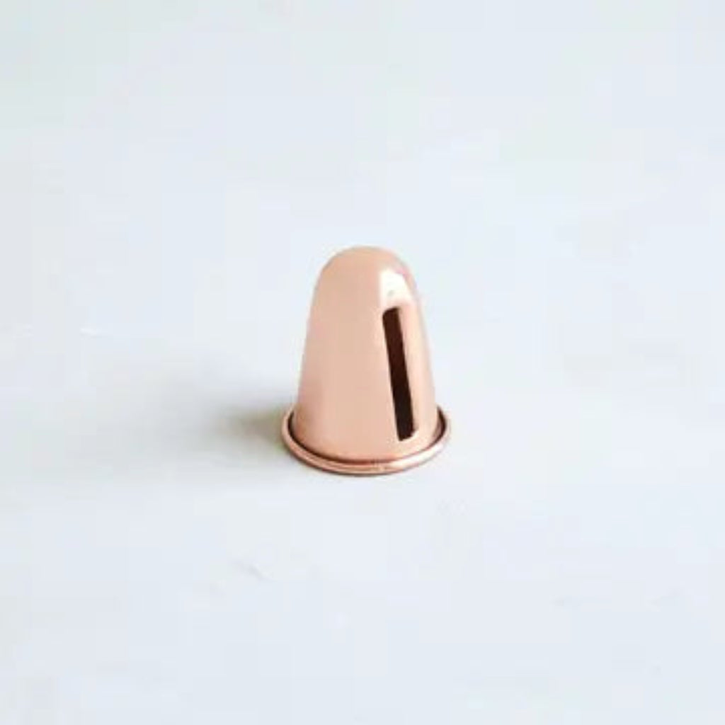 Copper-tone candle sharpener, metal cone with dark interior.