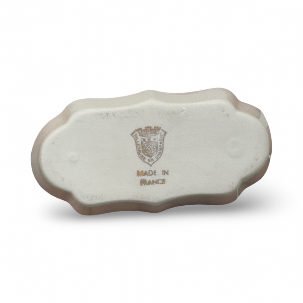 Light beige ceramic ashtray with scalloped rim and crest stamp on base.