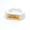 White ceramic ashtray with raised rim and Cognac Monnet logo on front