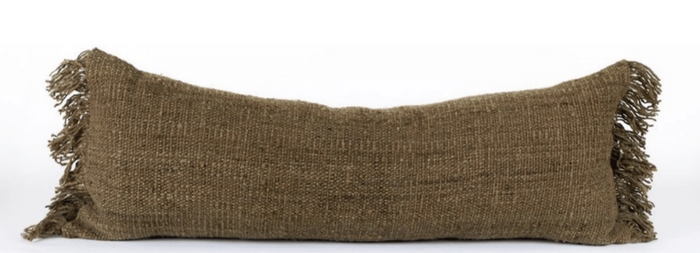 A rectangular green pillow with a textured, fringed edge, made of natural wool.