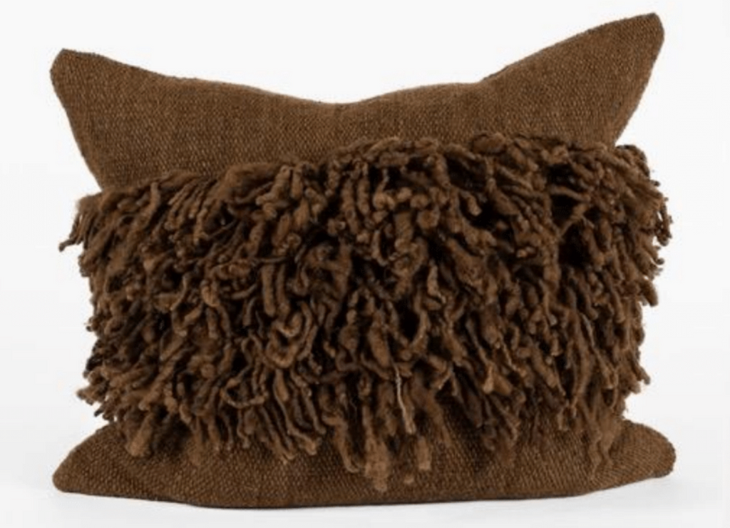 Brown pillow with textured fringe on a white background