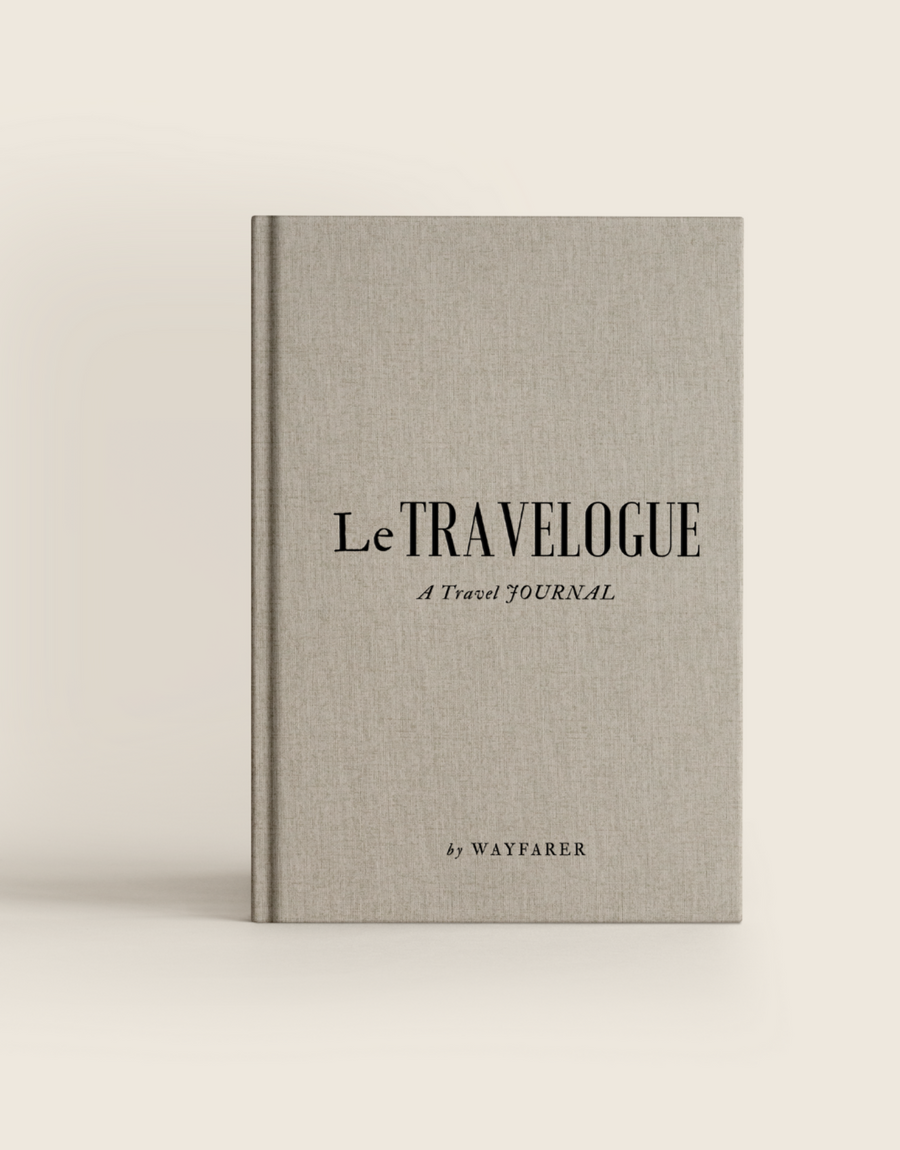 Gray fabric travel journal cover with “Le TRAVELOGUE” and gold Wayfarer mark