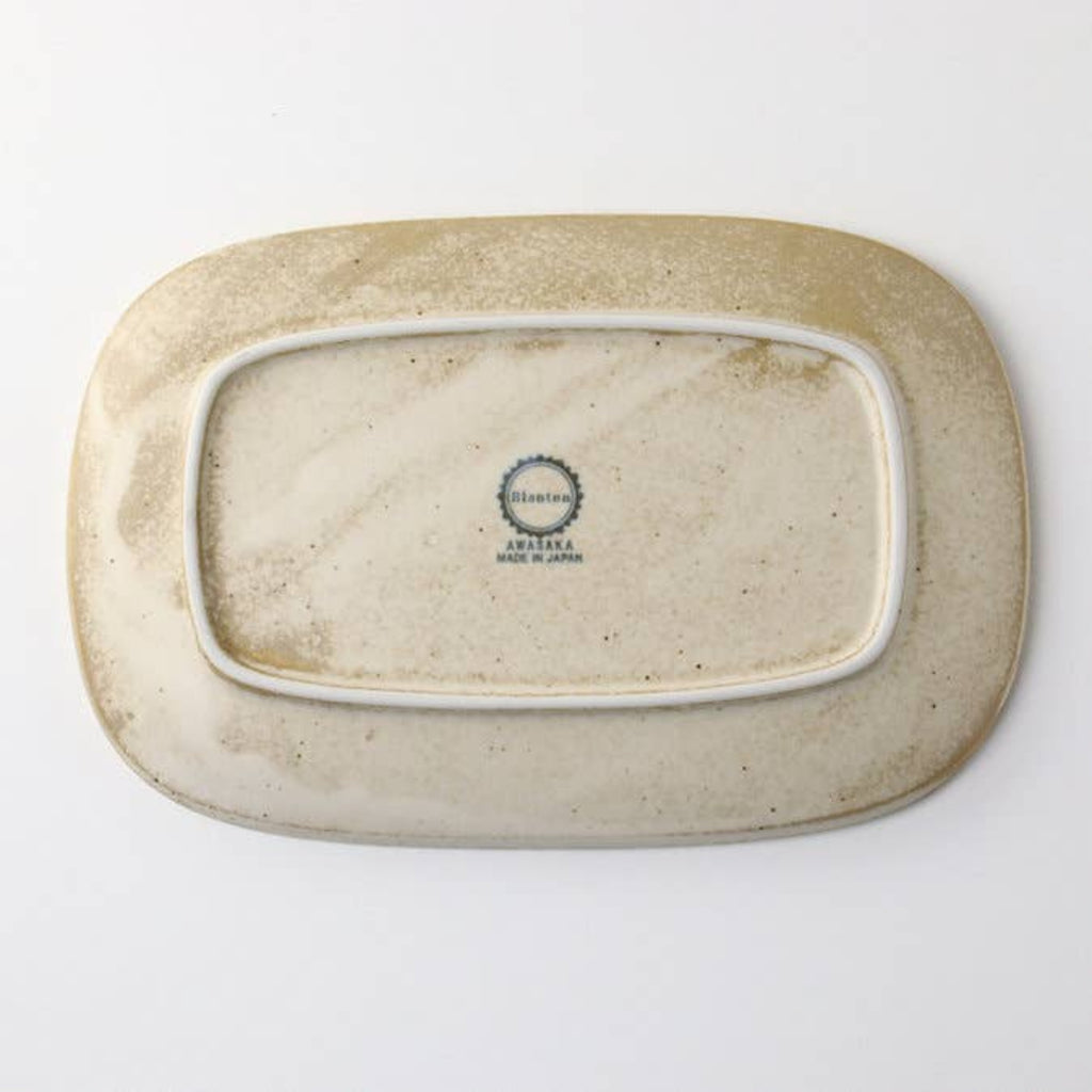 Speckled oval porcelain plate bottom with maker stamp