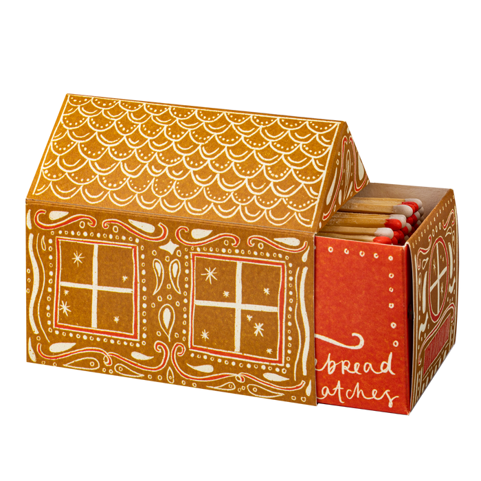 Gingerbread-style matchbox shaped like a house with red-brown and white icing print