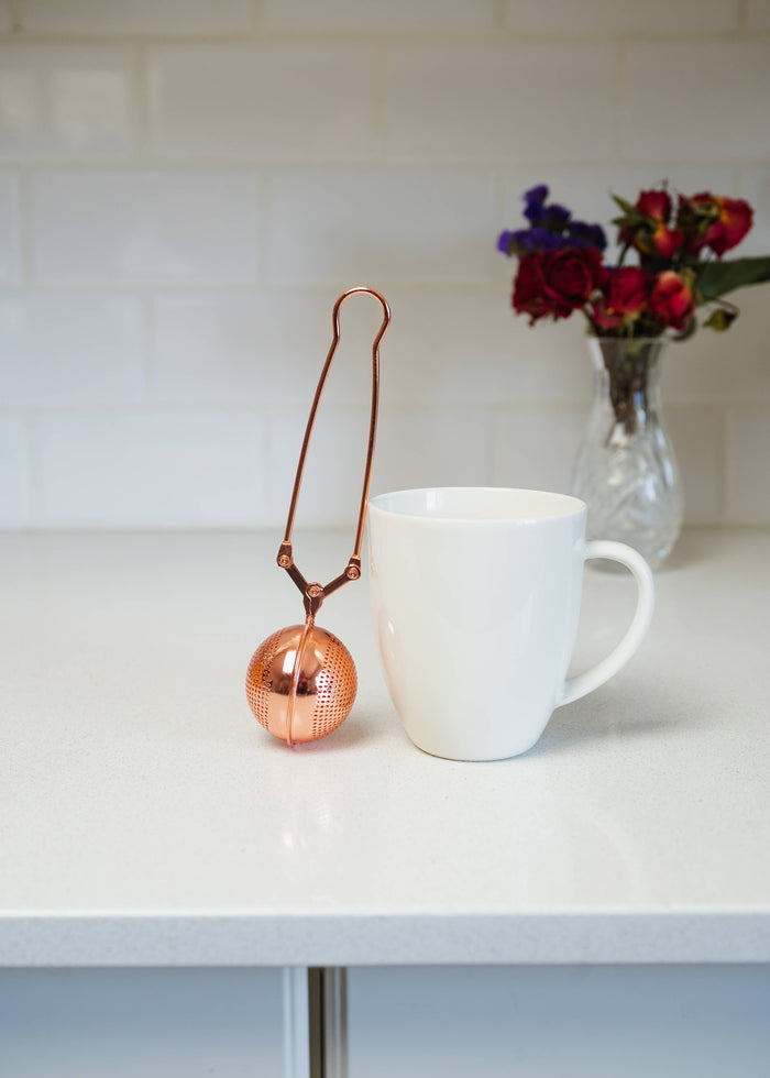 Rose gold stainless steel tea strainer with round mesh ball and long handle loop